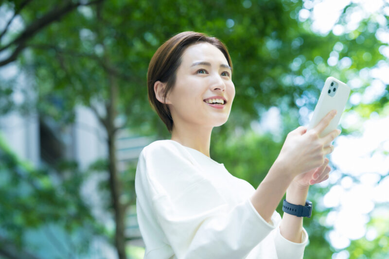 Young woman holding a smartphone outdoors