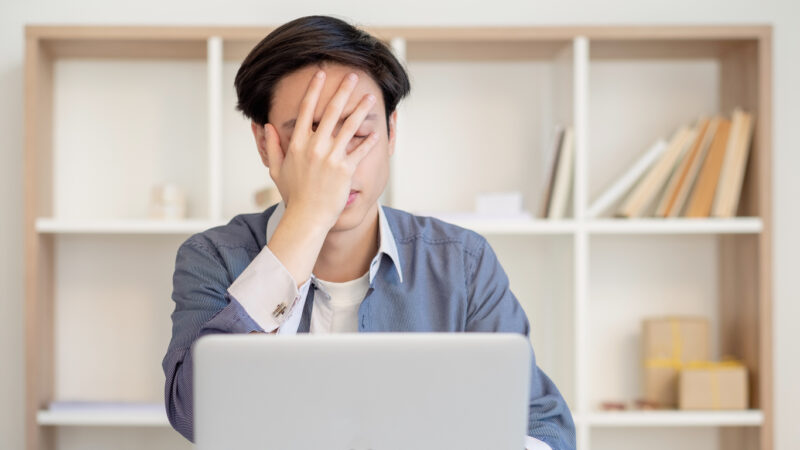 Depressed office worker. Deadline pressure. Professional anxiety. Disappointed ashamed asian project manager with laptop showing facepalm gesture.