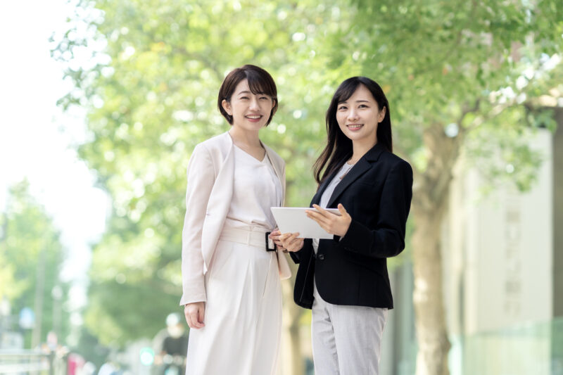Two women smiling in business district