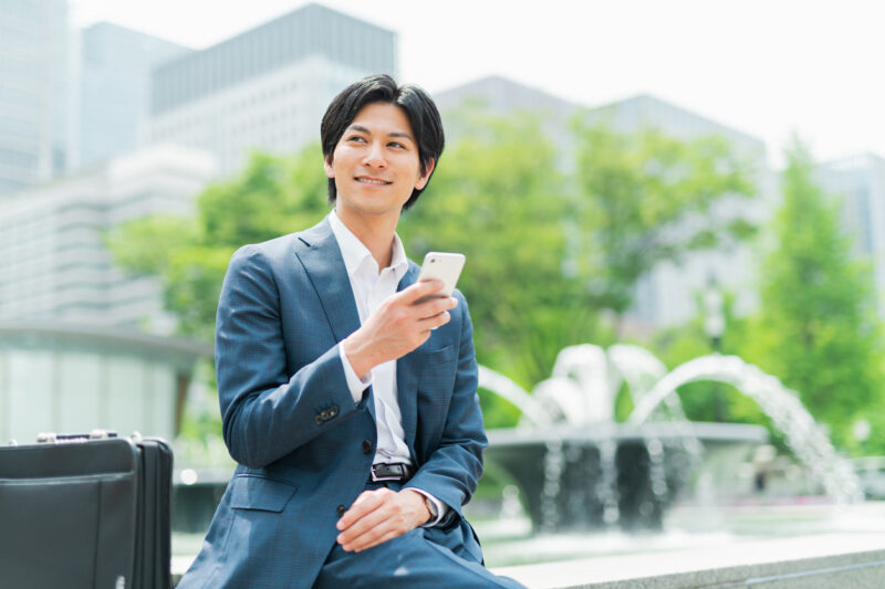 Young businessman checking his smartphone in the park