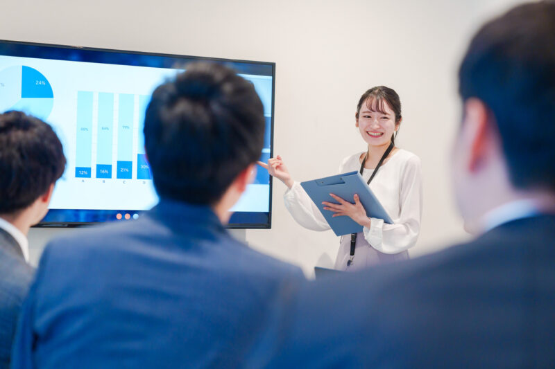 Young female employee giving a presentation at a remote meeting