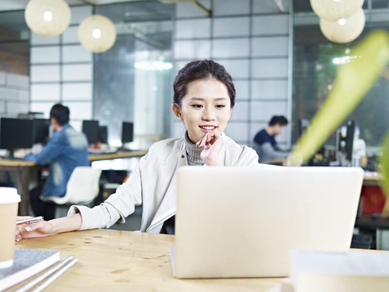 young asian business woman working in office using laptop computer.